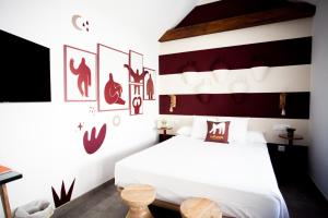a bedroom with a white bed with red accents at Lukanda Hospec Olehousing in Seville