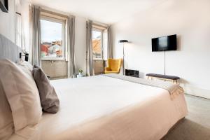 een slaapkamer met een groot wit bed en een tv bij Calacatta Housing in Porto