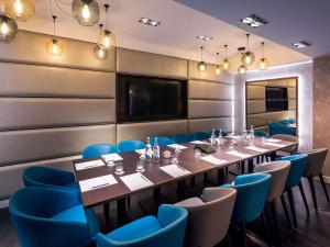 a conference room with a long table and blue chairs at Mercure London Hyde Park Hotel in London