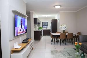 a living room and dining room with a television on a wall at Ecam in Antwerp