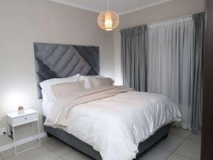 a bedroom with a white bed and a chandelier at Ecam in Antwerp