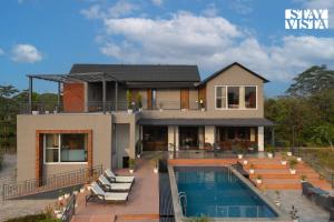 a house with a swimming pool in front of it at StayVista at Villa Aera with Pool, Lawn in Chandīgarh