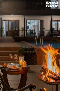 a fire pit with a table and glasses of wine at StayVista at Villa Aera with Pool, Lawn in Chandīgarh