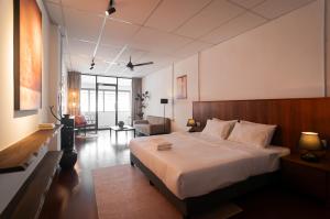 a bedroom with a large bed and a living room at Aayu Church St - 7 mins to Esplanade, George Town in George Town