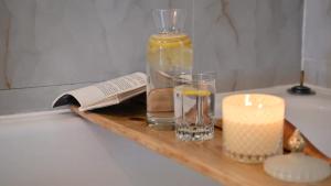 a candle and a bottle and a glass on a wooden tray at Mystic Twistic in Vîrfurile