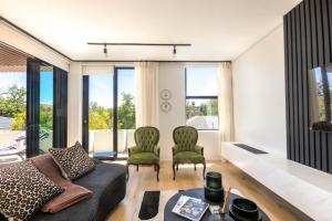 una sala de estar con un sofá y dos sillas en Aan de Meul Luxury Apartments, en Stellenbosch