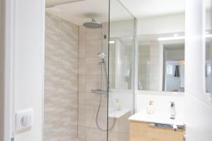 a bathroom with a shower with a sink and a mirror at Séjour Entre Océan et Centre-Ville in Hossegor