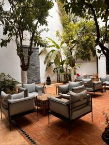 梅克内斯里亚德亚姆查旅馆的天井配有沙发、桌子和树木