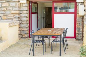 a wooden table and chairs in front of a door at Séjour Entre Océan et Centre-Ville in Hossegor +12 photos