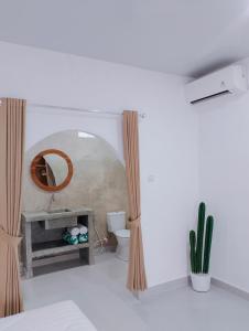 a bathroom with a sink and a mirror and a toilet at My Boo Private House in Sampalan