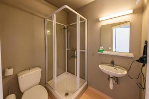 a bathroom with a shower and a toilet and a sink at The Stykkishólmur Inn by Ourhotels in Stykkishólmur