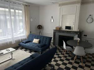 a living room with a blue couch and a table at Larcadian in Boulogne-sur-Mer