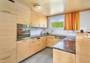a large kitchen with wooden cabinets and a window at Hof Höchi in Bruggen
