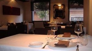 una mesa con dos platos de comida y copas de vino en Hotel Diego's, en Cambrils