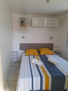 a bedroom with a bed with yellow and blue stripes at mobilhome 508 in Parentis-en-Born