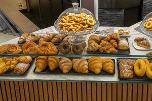 a bunch of different types of pastries on a counter at Bed Cinecittadue in Rome