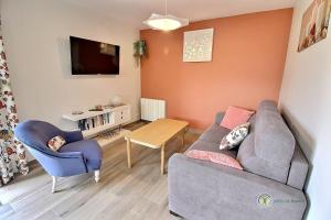 een kleine woonkamer met een bank en een tafel bij Le p'tit ancrage in Erquy