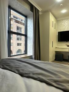 a bedroom with a bed and a large window at Nord Gate Avenue Hotel in Aghk'ilisa
