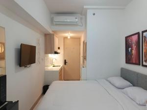 ein Schlafzimmer mit einem großen weißen Bett in einem Zimmer in der Unterkunft Apartment Tokyo Riverside By Seagull Luxury Apartment in Gedong + 10 Fotos