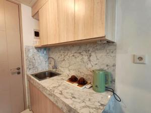 eine Küche mit Spüle und Arbeitsplatte in der Unterkunft Apartment Tokyo Riverside By Seagull Luxury Apartment in Gedong