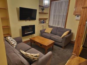 a living room with two couches and a flat screen tv at Hartwood Cottage - 33 Longwestgate in Scarborough