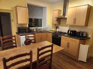 a kitchen with wooden cabinets and a wooden table at Hartwood Cottage - 33 Longwestgate in Scarborough
