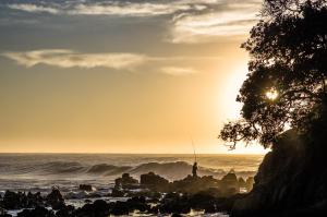 a person fishing on the beach at sunset at Mdumbi lodge in Ngqeleni