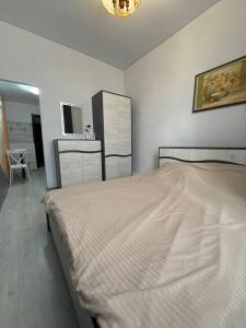 a white bedroom with a bed and a kitchen at Park apartament in Bălţi