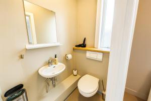 a bathroom with a sink and a toilet and a mirror at The Stykkishólmur Inn by Ourhotels in Stykkishólmur