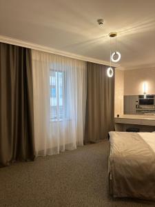 a hotel room with a bed and a window at Nord Gate Avenue Hotel in Aghk'ilisa