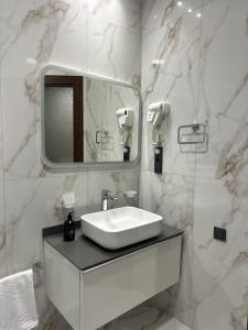 a white bathroom with a sink and a mirror at Nord Gate Avenue Hotel in Aghk'ilisa +24 photos