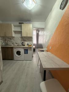a kitchen with a washing machine and a table at Park apartament in Bălţi