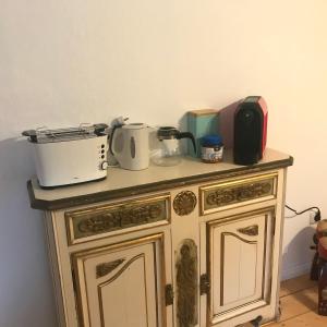 a wooden cabinet with appliances on top of it at Chez Elly in Celle