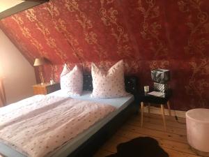 a bedroom with a bed with a red wall at Chez Elly in Celle