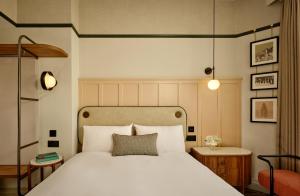 ein Schlafzimmer mit einem großen weißen Bett und einem Stuhl in der Unterkunft The Grand Hotel Leicester by The Unlimited Collection in Leicester + 75 Fotos