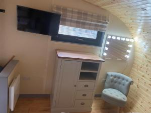 une petite pièce avec une télévision, une armoire et une chaise dans l'établissement Willowbrook Luxury Log Cabin with private hot tub, à Kings Norton
