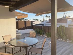 a patio with a glass table and chairs on a deck at Bungalow Maspalomas, Jacuzzi in Maspalomas