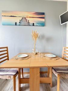a dining room table with a painting on the wall at Le Pignon - TV, 1min de la Mer, Central in Saint-Jean-de-Monts