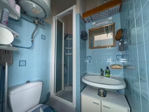 a blue tiled bathroom with a sink and a shower at Le Pignon - TV, 1min de la Mer, Central in Saint-Jean-de-Monts