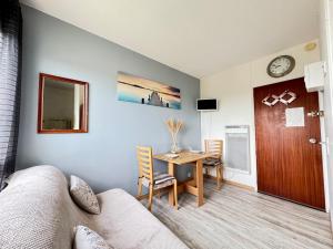 a living room with a table and a dining room at Le Pignon - TV, 1min de la Mer, Central in Saint-Jean-de-Monts