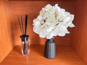 two vases with white flowers in them on a table at Le Pignon - TV, 1min de la Mer, Central in Saint-Jean-de-Monts