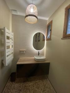 a bathroom with a sink and a mirror at Maison de Charme Vue Exceptionnelle Mer & Montagne in Campomoro
