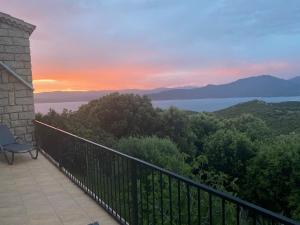 Maison de Charme Vue Exceptionnelle Mer & Montagne في كامبومورو: شرفة مطلة على المحيط وقت الغروب