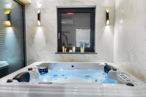 een badkuip in een badkamer met een raam bij Charming Villa Harmonia with Heated pool and Indoor Jacuzzi surrounded by nature in Pićan