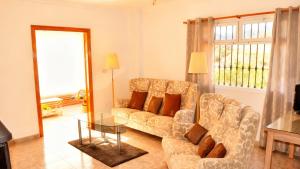 salon z kanapą i szklanym stołem w obiekcie Villa Clara beautiful villa, heated pool, 10 min beach by Rentasunnyplace w mieście Arenas +16 zdjęć