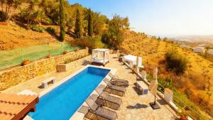 obraz basenu z krzesłami wokół niego w obiekcie Villa Clara beautiful villa, heated pool, 10 min beach by Rentasunnyplace w mieście Arenas