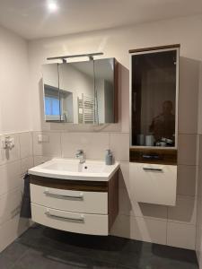 Ski und Wander Ferienhäuser Galsterberg-Blick Pruggern - Schladming-Dachstein في Michaelerberg: حمام أبيض مع حوض ومرآة