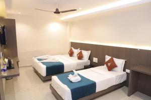 une chambre d'hôtel avec deux lits avec des serviettes dessus dans l'établissement CR Residency By Glitz Hotels, à Mumbai