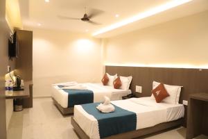 une chambre d'hôtel avec deux lits et une télévision dans l'établissement CR Residency By Glitz Hotels, à Mumbai 7 autres photos