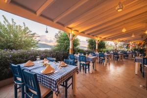 ein Restaurant mit Tischen und Stühlen auf einer Terrasse in der Unterkunft Bodrum Holiday Resort & Spa in Bodrum City